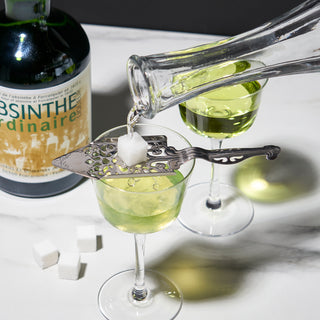 SERVING THE GREEN FAIRY - To serve absinthe the traditional way, place the absinthe spoon over your glass of absinthe, place a sugar cube on top, and gently pour cool water over the cube to dissolve it and dilute your drink.