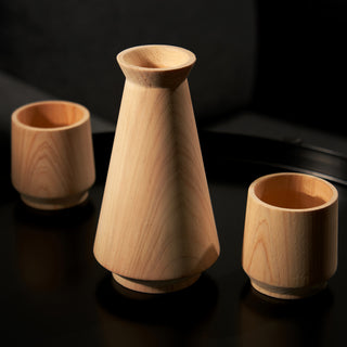 HINOKI CYPRESS WOOD CUP AND CARAFE: Crafted from Hinoki cypress, which has a subtle eucalyptus and pine scent that enhances sake, each drink cup holds 3 oz. The serving carafe holds 10 oz. and has a minimalist silhouette.